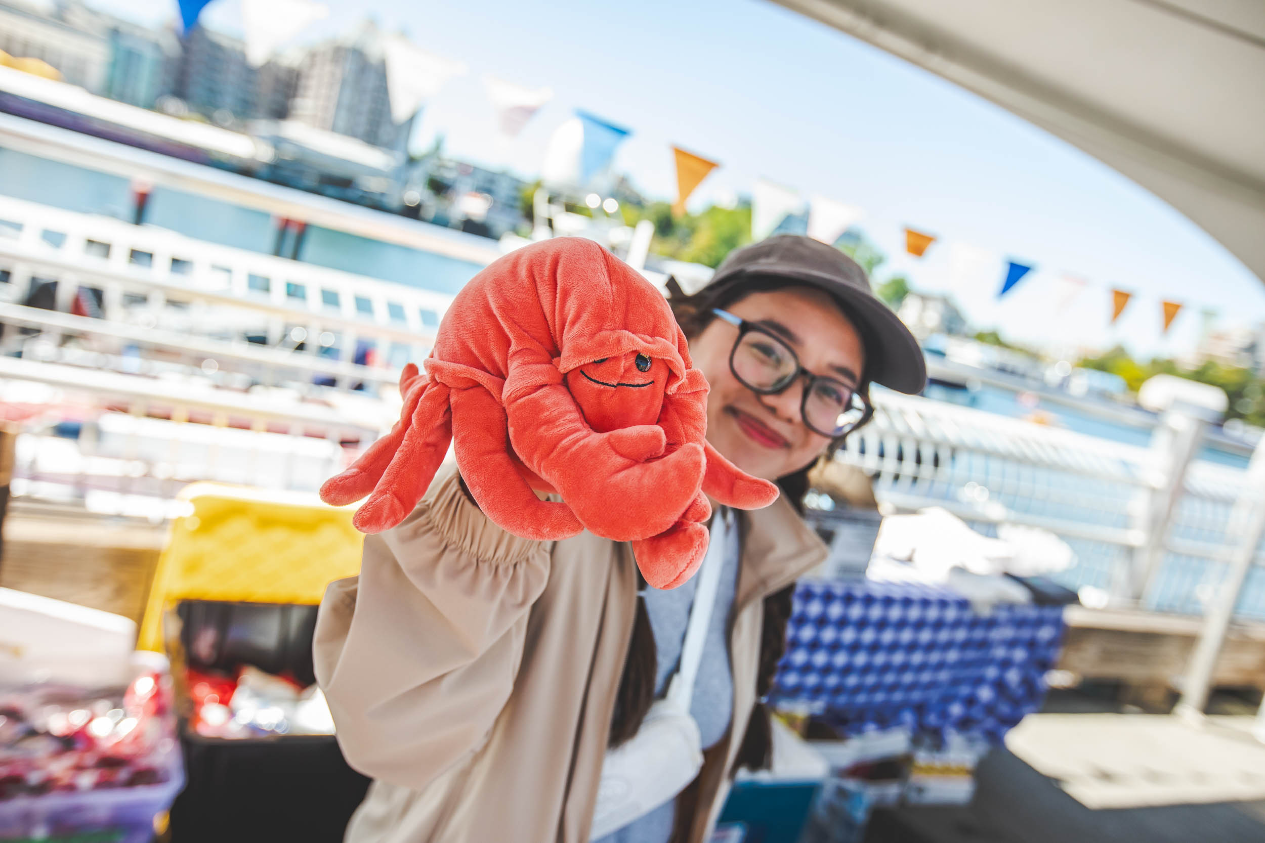 Festival-goer holding a crab plushie at BC CrabFest, Victoria harbour