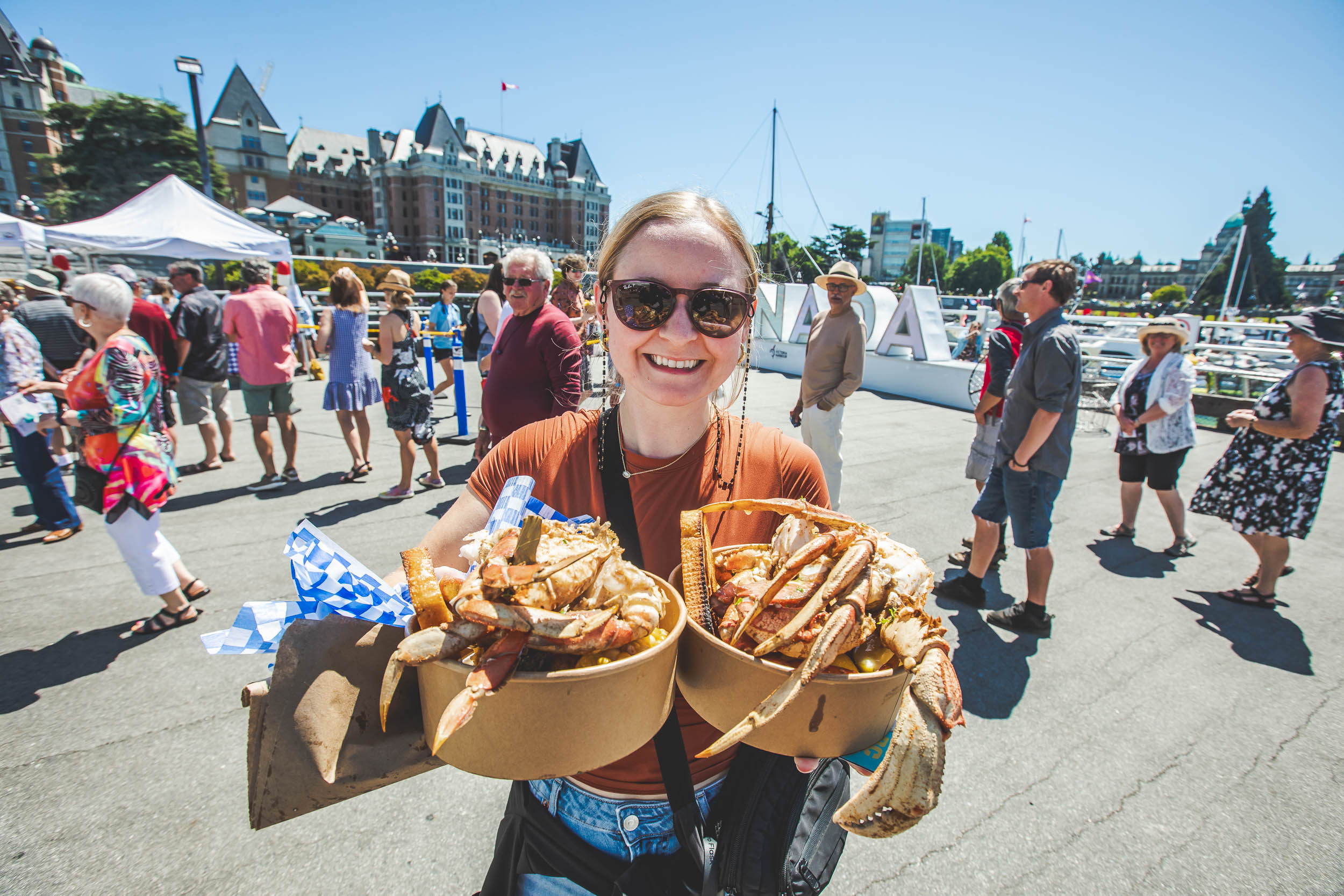 Guest holding fresh BC Dungeness crab boil buckets at BC CrabFest, Victoria Inner Harbour